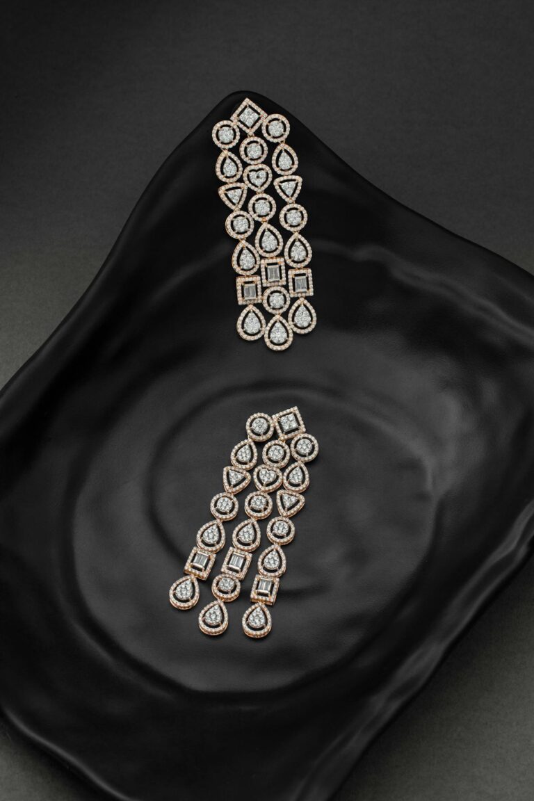 Elegant diamond earrings displayed on a black flowy plate, showcasing luxury and style.